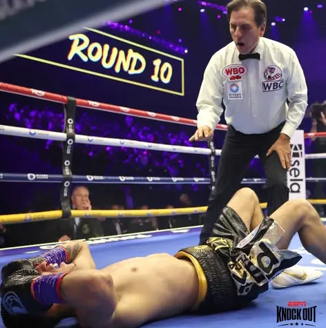 Fernando Puma Martínez en la lona no puede ponerse de pie mientras el árbitro procede al conteo