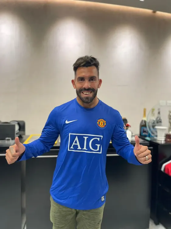 Carlos Tevez sorteando una camiseta del Manchester